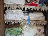 a wooden cabinet filled with lots of clothes and other items