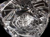 a glass heart shaped object with a bird on it