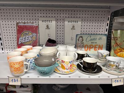 de nombreuses tasses et soucoupes sur l'étagère du magasin