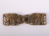une paire de boucles anciennes en laiton représentant des éléphants, sur fond blanc
