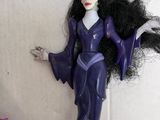 a figurine of a woman with long black hair in a purple dress