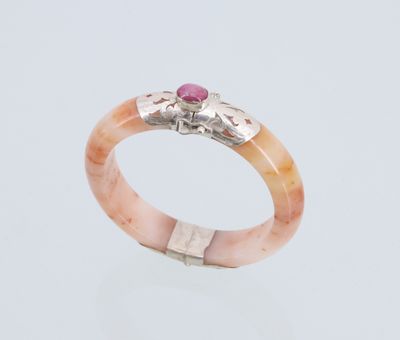 un gros plan d'une bague sertie d'une pierre rose