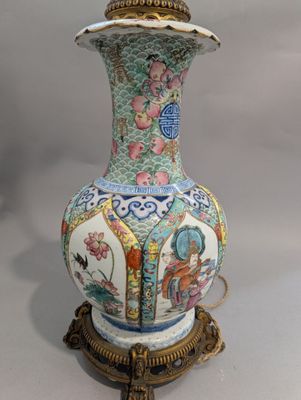 un vase posé sur un socle sur lequel se trouve une lampe