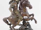 statue of a man on a horse with a flag on a pedestal