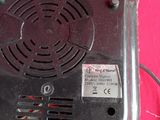 a black fan on a pink sheet with a pink background