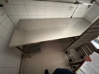 a person standing in a kitchen reading a paper