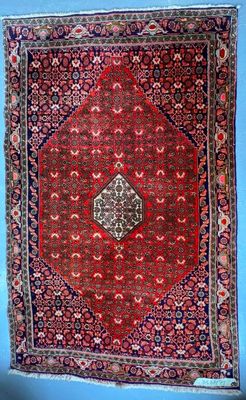 un tapis rouge accroché à un mur bleu dans une pièce