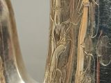 a silver vase that is sitting on a table