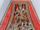 a silver and red metal object with a picture of a man and a woman on it