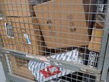 a metal cart with many boxes in it on the street