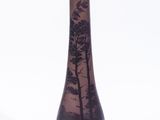 un vase violet orné d'arbres sur fond blanc
