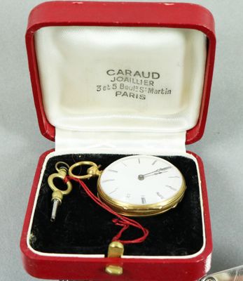une petite boîte rouge contenant une clé et une horloge