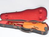 un étui à violon contenant un violon, posé sur une surface blanche