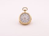 a close up of a gold pocket watch on a white surface