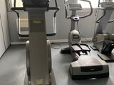 a gym room with a row of stationary exercise machines
