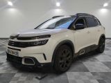 un SUV Citrole blanc garé dans une pièce au sol en damier