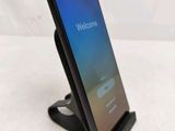 a close up of a cell phone on a stand on a white surface