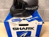 the shark helmet is sitting on top of the box next to the bag