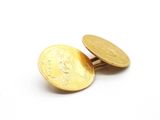 des boutons de manchette en forme de pièces d'or sur une surface blanche, avec un fond blanc