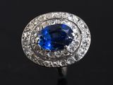 a close up of a blue sapphire and diamond ring