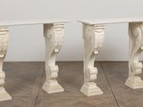 pair of white marble console tables with carved details
