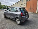 a small car parked in a parking lot near a building