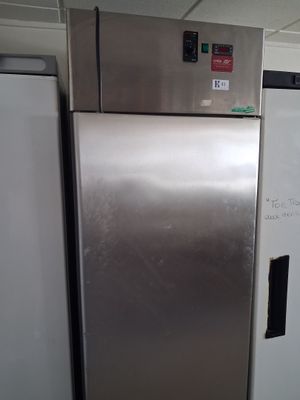 a silver refrigerator and a white refrigerator freezer in a kitchen