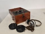 une boîte en bois sur laquelle sont posés un casque audio et une paire d'écouteurs