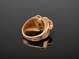 an image of a gold ring sitting on top of a black surface