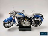a blue and white motorcycle on a black stand