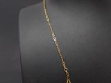 a gold necklace on a mannequin with a black background