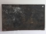 a black piece of metal sitting on a white surface