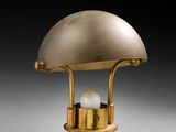 une image représentant une lampe de table dorée sur laquelle est posée une ampoule