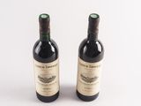 two bottles of wine sitting next to each other on a white surface