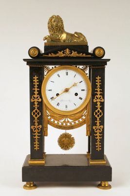 a black and gold clock with a golden lion on top