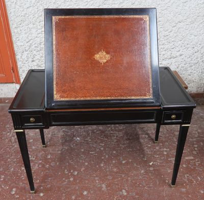 une table noire sur laquelle est posé un plateau en cuir marron