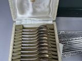 a lot of silver spoons in a box on a table