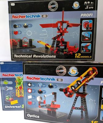 trois boîtes de lego technics posées sur une table