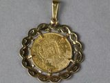 a close up of a gold coin with a chain around it