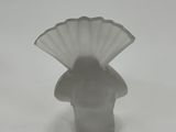 a small white vase with a fan on top of it