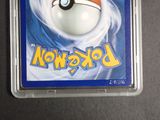 a pokemon card in a plastic case on a table