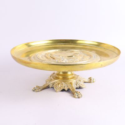 assiette en or ornée d'une tête de lion, posée sur un socle