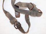 a pair of old leather straps on a white surface
