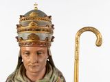 figurine of a statue of a man dressed in a crown and holding a cane