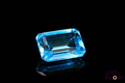 a blue topazte gems on a black surface