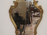 a mirror hanging on the wall with a bench in front of it