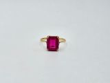une bague en tourmaline rose avec un anneau en or sur un fond blanc