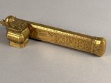 an image of a gold lighter sitting on top of a table
