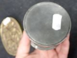 a person holding a silver object in their hand next to a gold coin