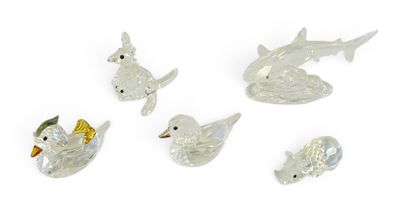 quatre figurines d'animaux en verre transparent posées sur un fond blanc